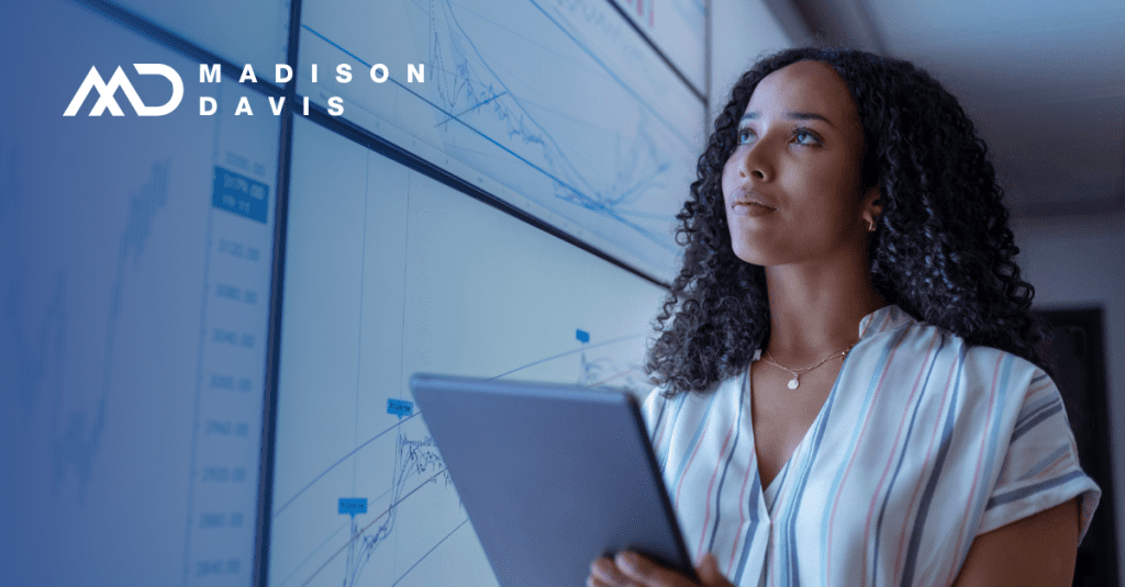 Woman holding a tablet views screens displaying graphs, studying finance and market conditions