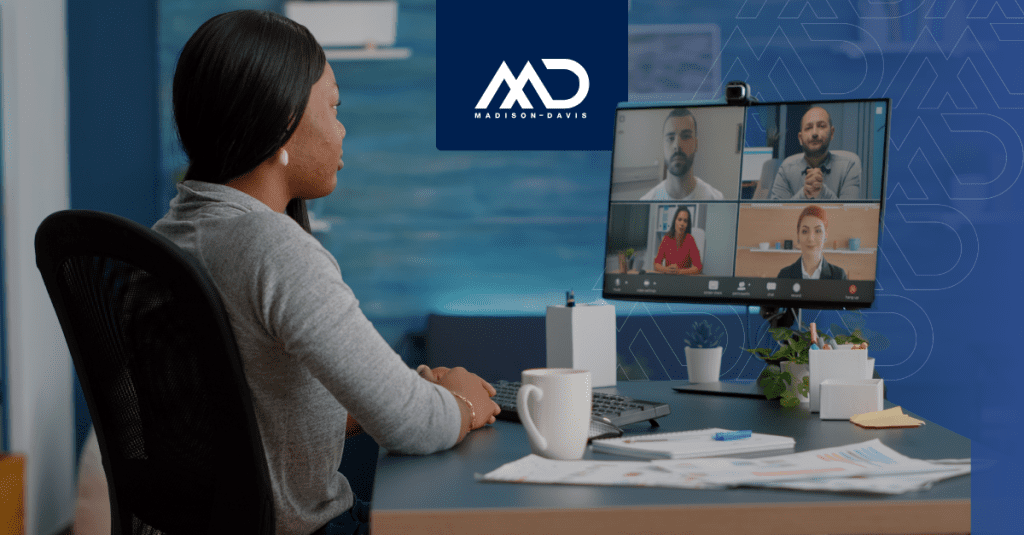 Employee sits at desk in a video conference