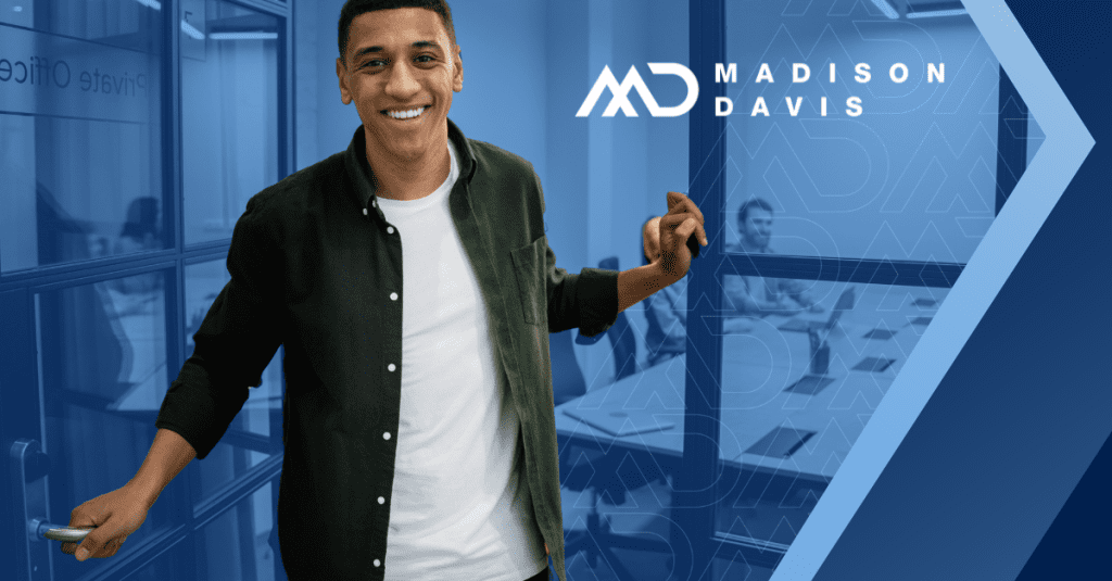 Smiling employee holding the door open in an office doorway