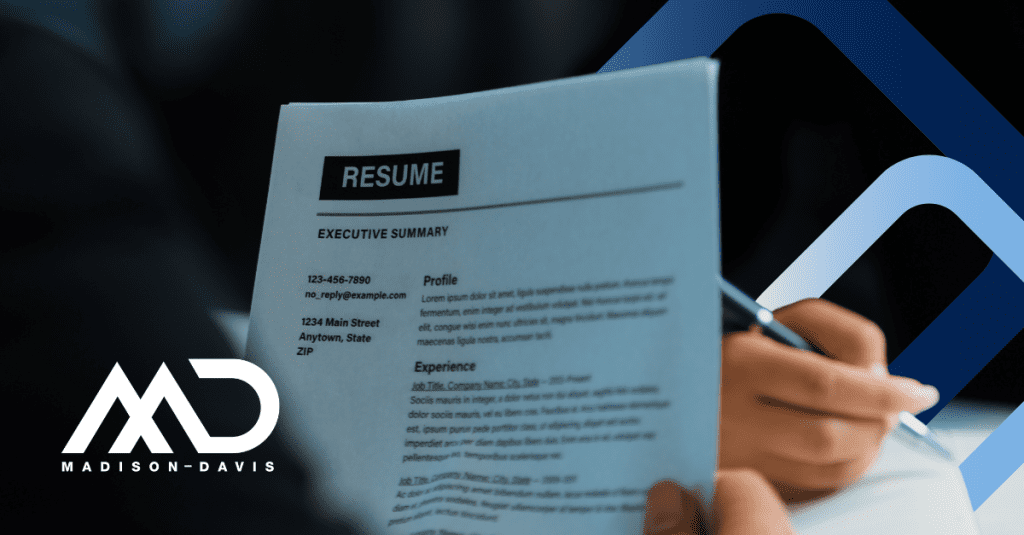 A hand holds up a resume labelled "resume" and starting with an executive summary