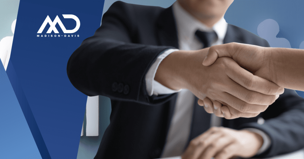 Close up view of a handshake with a man in coat and tie