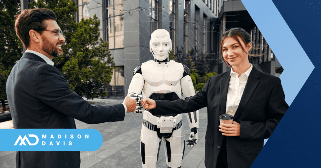 A financial services employee bumps fists with a manager and and a humanoid robot.