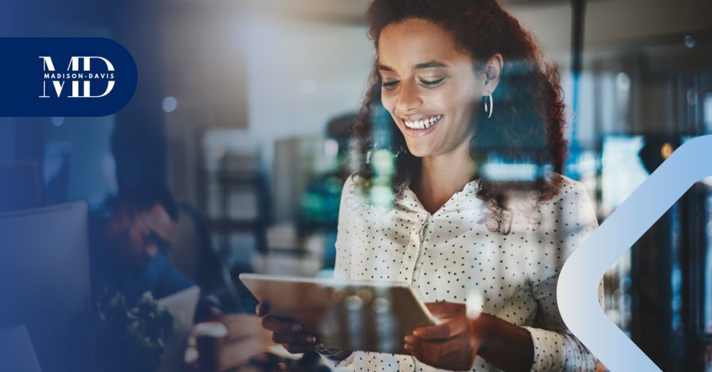 Employee looks at a mobile tablet smiling